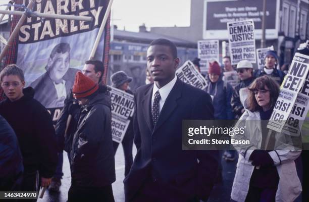 Duwayne Brooks, witness to the murder of his friend Stephen Lawrence, takes part in a Family Justice campaign rally, protesters carry a banner...
