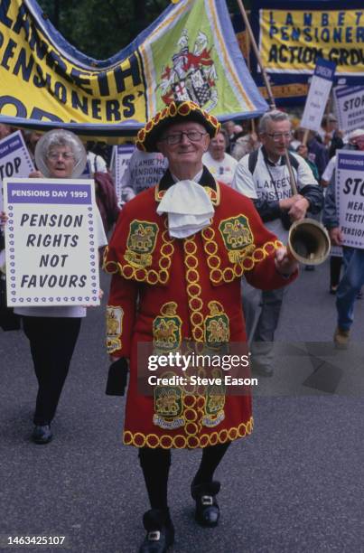 Lambeth pensioners led by a costumed town crier with a handbell taking part in a Pensions Day protest, one woman holds a placard reading 'Pensions...