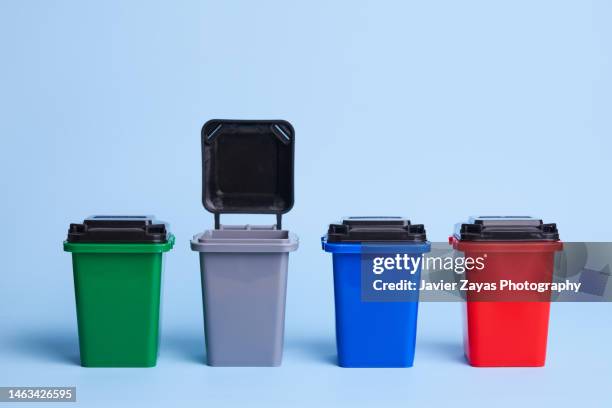 different color recycling garbage containers on blue background - skip bin stock pictures, royalty-free photos & images