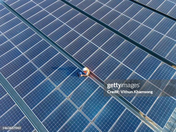 aerial view of engineers and laptop at solar panels roof - pannello solare foto e immagini stock