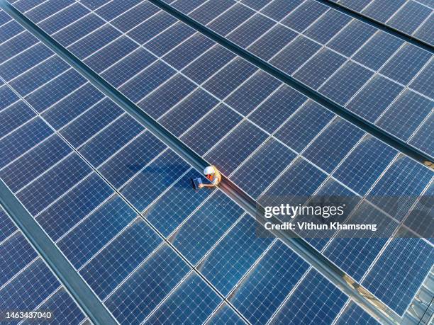 aerial view of engineers and laptop at solar panels roof - solar panel stock pictures, royalty-free photos & images