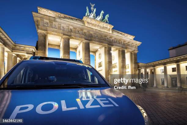 police car in front of the brandenburg gate (berlin, germany) - duitse cultuur stockfoto's en -beelden