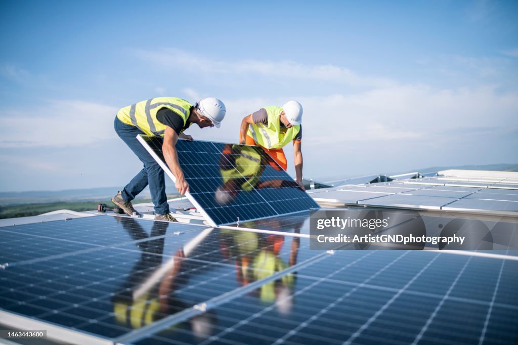 Zwei Arbeiter installieren Photovoltaikanlage.