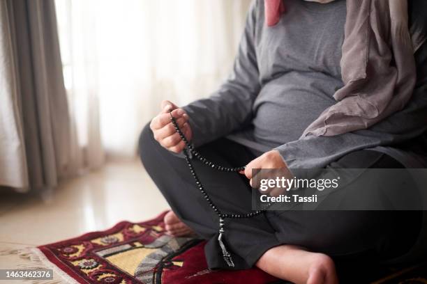 muslim prayer beads, pregnancy and woman pray to allah, god or holy spirit for islamic religion, faith and baby support. spiritual worship, maternity hope and pregnant arabic person praying on carpet - pregnant muslim stockfoto's en -beelden