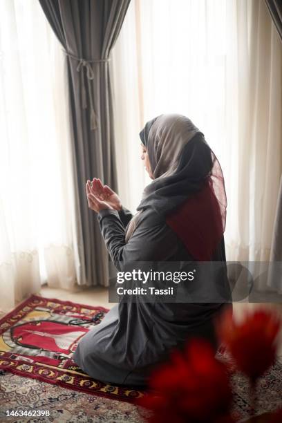 gebet, anbetung und islamische frau beten zu allah, gott oder heiligem geist für islamische religion, glauben und spirituelle unterstützung. hoffnung, muslimisches zuhause und muslimische person, die auf dem teppich im erdgeschoss oder boden in istanbul  - prayer mat stock-fotos und bilder