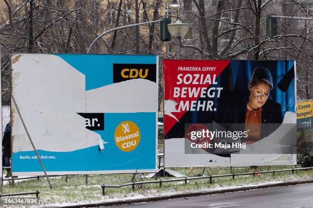 Torn banners with an election campaign posters of German Christian Democrats , and Berlin Governing Mayor and Social Democrat Franziska Giffey are...