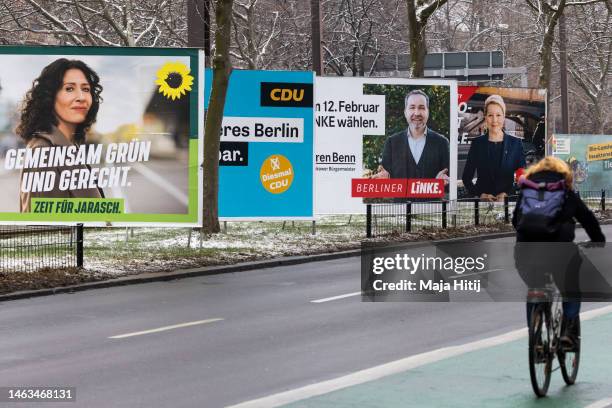 Woman bikes past an election campaign posters that show Greens Party Berlin city Mayor Bettina Jarasch, German Christian Democrats , Die Linke and...
