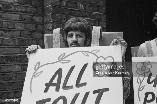 Drummer Ringo Starr of English rock and pop group The Beatles posed with a sandwich board during a press call to promote the band's performance of...