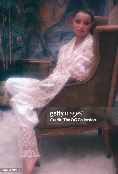 Portrait of American model and actress Sheila Kennedy as she sits in a wingback chair, New York, New York, September 1983. The photo was taken, in...