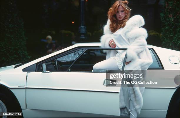 American model and actress Victoria Lynn Johnson poses with one leg in the open door of her Lotus Esprit sportscar, June 1977. The car was one of the...