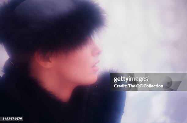 Profile portrait of American model and actress Sheila Kennedy in a black fur hat and matching jacket, New York, New York, September 1983. The photo...