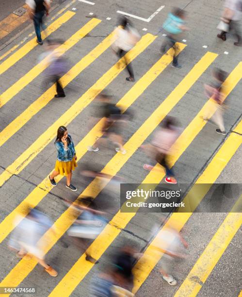 slow motion city crosswalk - standing out from the crowd stockfoto's en -beelden