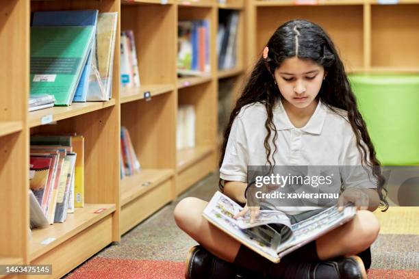 hispanic schoolgirl looking at graphic novel - literacy stock pictures, royalty-free photos & images