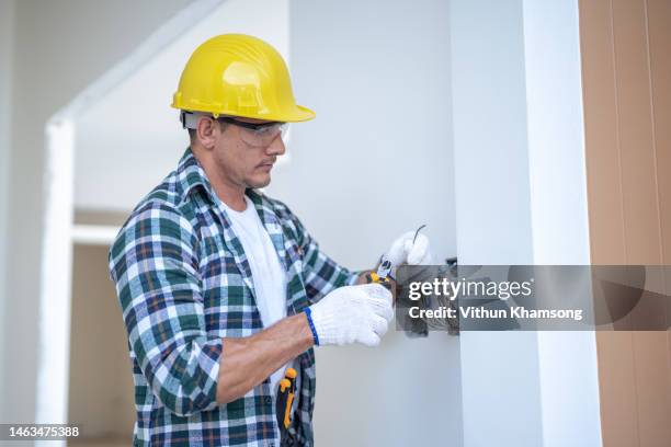 male electrician working and install wire at construction site - lightning home stock pictures, royalty-free photos & images