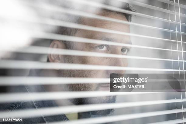 concerned citizen looking out the window - sad business stock pictures, royalty-free photos & images