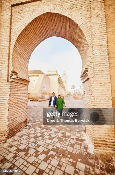 wide shot of senior couple exploring the medina of marrakech - idyllic retirement stock pictures, royalty-free photos & images