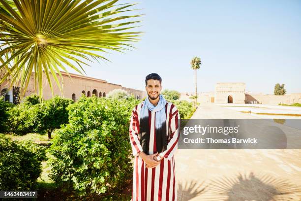 medium wide shot portrait of tour guide standing in el badi palace - maroc school stock-fotos und bilder