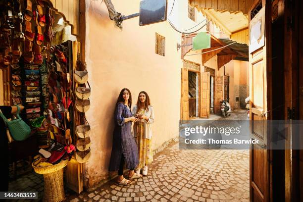 wide shot of sisters exploring the souks of marrakech during vacation - moroccan girls stock pictures, royalty-free photos & images