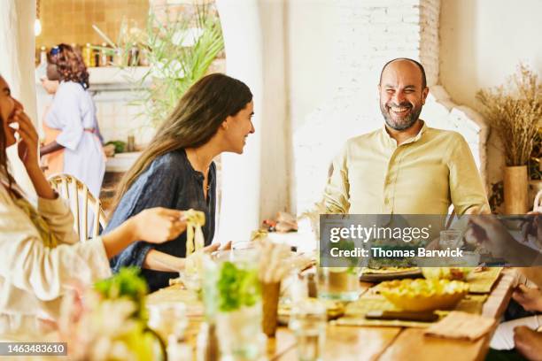 medium shot of laughing family dining in outdoor restaurant - halbnahe-einstellung stock-fotos und bilder