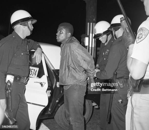 Rioters are arrested and their weapons taken to police headquarters at the riots in Watts for the third day.