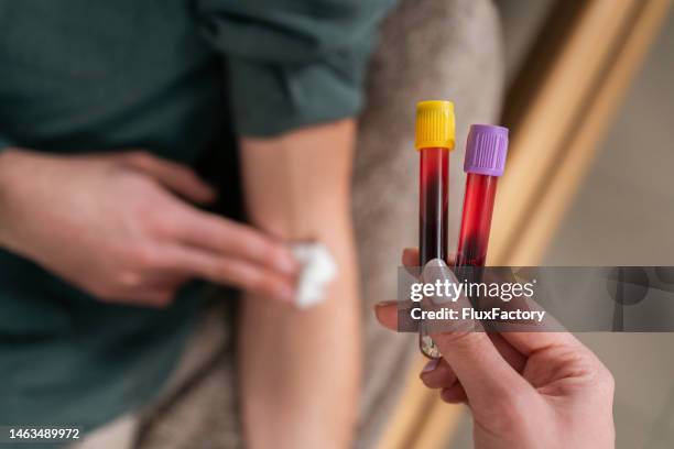 krankenschwester mit blutentnahmeröhrchen - medizinischer test stock-fotos und bilder