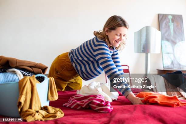 woman decluttering her wardrobe, deciding what to give away - de clutter stock pictures, royalty-free photos & images