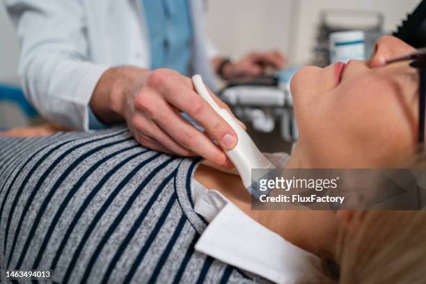 endocrinologist doing ultrasound of thyroid gland on a senior female patient - carotid artery stock pictures, royalty-free photos & images
