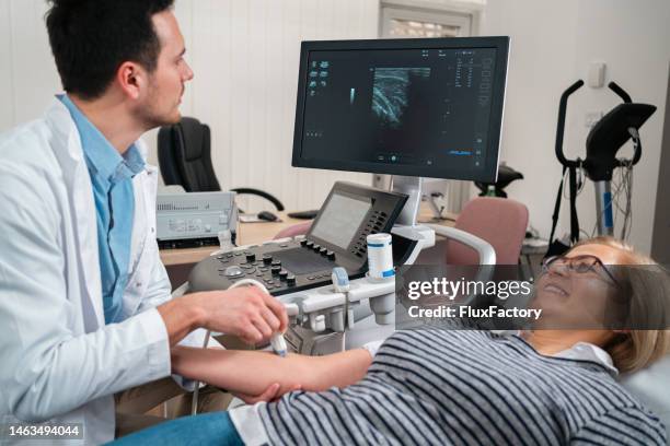 arzt, der den doppler-ultraschalltest durchführt, untersucht blutgefäße bei einer älteren patientin - doppler stock-fotos und bilder