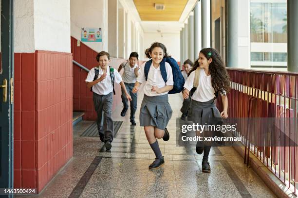 smiling classmates racing in school hallway - latin boy stock pictures, royalty-free photos & images