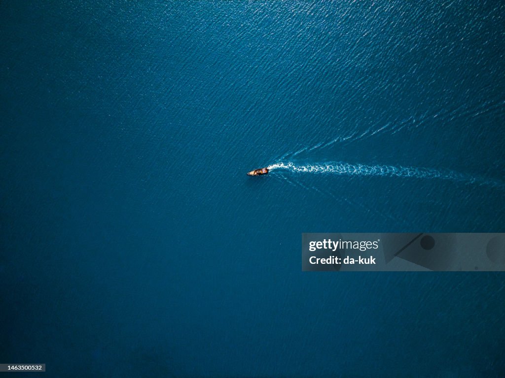 Aerial view of boat in the sea. Travel freedom concept. Shoot directly above