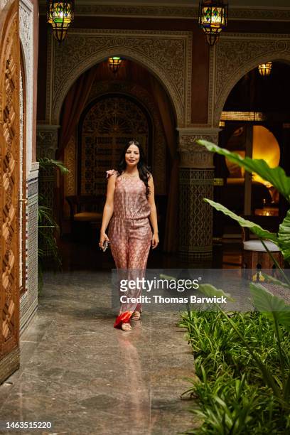 wide shot of woman walking through lobby of luxury hotel - morocco interior ストックフォトと画像