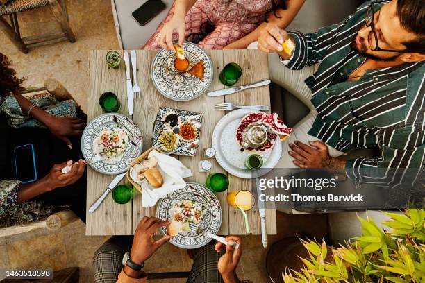 wide shot overhead view of friends sharing dinner at rooftop restaurant - table top imagens e fotografias de stock