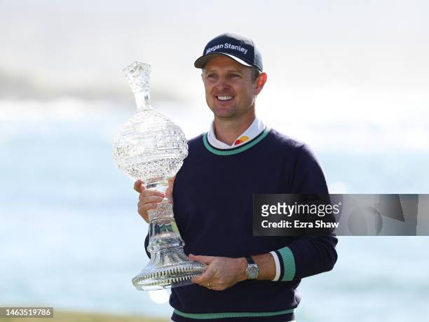Justin Rose of England holds the trophy after victory on the 18th green during the continuation of the final round of the AT&T Pebble Beach Pro-Am at...
