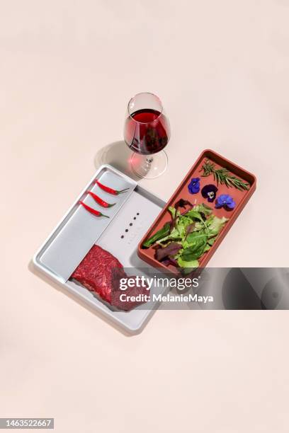 low carb raw beef steak meat on plate with red wine, spices and salad on colorful background - low alcohol drink stock pictures, royalty-free photos & images