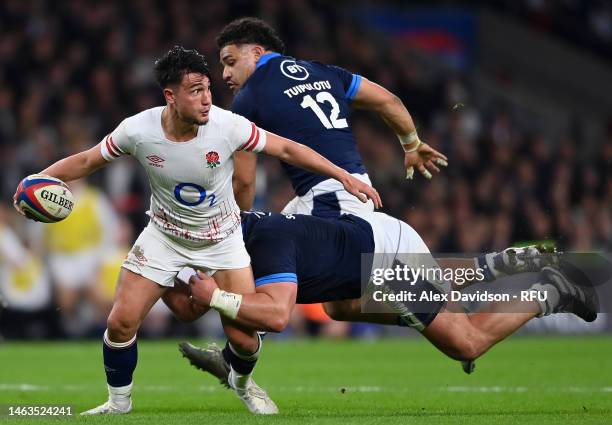 Marcus Smith of England breaks past Pierre Schoeman and Sione Tuipulotu of Scotland during the Six Nations Rugby match between England and Scotland...