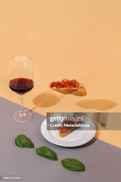 rotweinglas mit italienischem essen bruschetta-vorspeisen auf buntem hintergrund - foodstyling stock-fotos und bilder