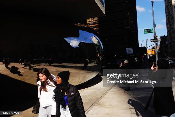People take photos in front of Anish Kapoor’s mirrored bean sculpture at the base of 56 Leonard Street on February 06, 2023 in New York City....