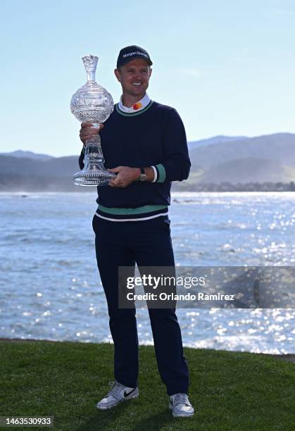 Justin Rose of England poses with the trophy on the 18th hole after victory during the continuation of the final round of the AT&T Pebble Beach...