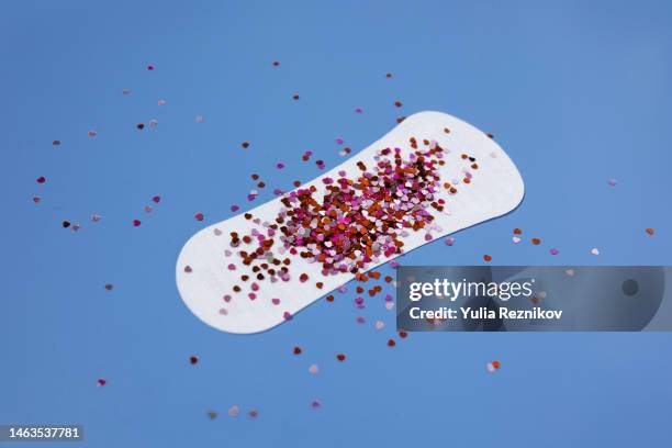 bloodstained sanitary pad on the blue background - period stock pictures, royalty-free photos & images