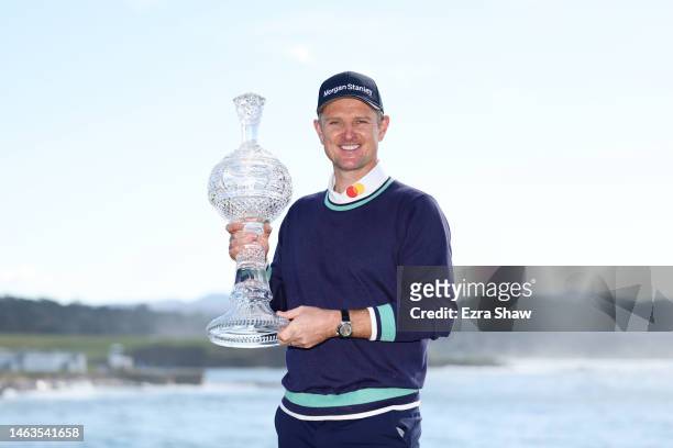 Justin Rose of England celebrates with the trophy on the 18th green after winning during the continuation of the final round of the AT&T Pebble Beach...