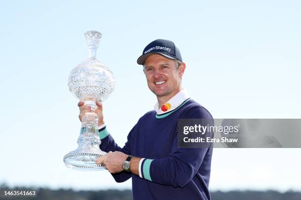 Justin Rose of England celebrates with the trophy on the 18th green after winning during the continuation of the final round of the AT&T Pebble Beach...