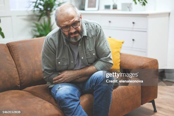 reifer erwachsener mann im innenraum (negative emotion) - diarrhö stock-fotos und bilder