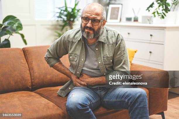 mature adult man in home interior ( negative emotion) - crotch stock pictures, royalty-free photos & images