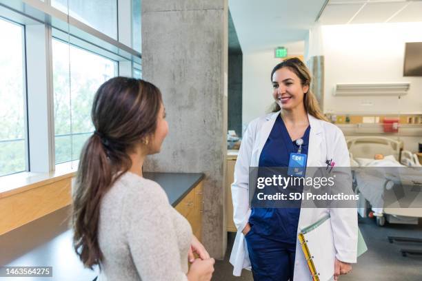 un médecin souriant apporte de bonnes nouvelles au membre de la famille du patient - infirmier praticien photos et images de collection