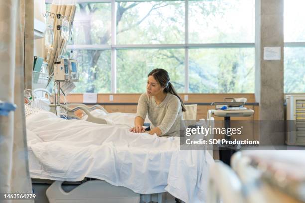 in er, woman stands up to comfort distressed family member - er visit stock pictures, royalty-free photos & images