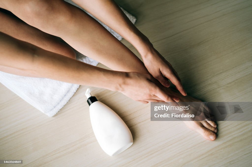White plastic bottle with a dispenser in the hands of a woman