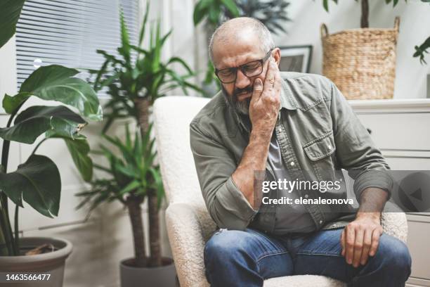 mature adult man in home interior ( negative emotion) - dor de dentes imagens e fotografias de stock