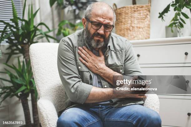hombre adulto maduro en el interior del hogar (emoción negativa) - sin aliento fotografías e imágenes de stock