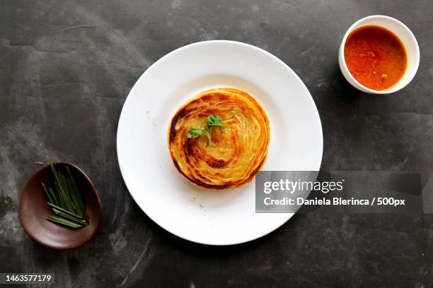 paratha bread or canai bread or roti maryam,favorite breakfast dish served on plate,giurgiu,romania - roti canai stock pictures, royalty-free photos & images