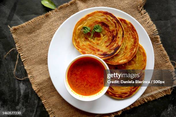 paratha bread or canai bread or roti maryam,favorite breakfast dish served on plate,giurgiu,romania - roti canai stock pictures, royalty-free photos & images